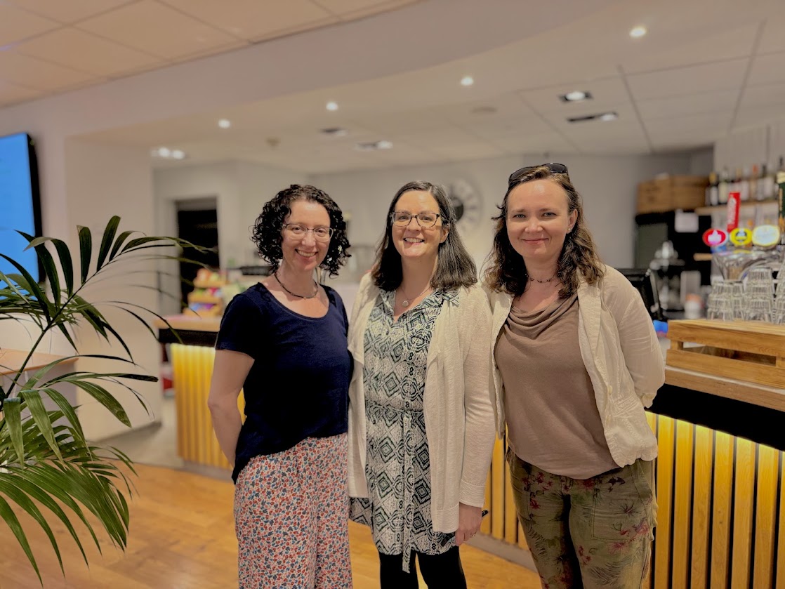 three of ding team of organisers stand and smile